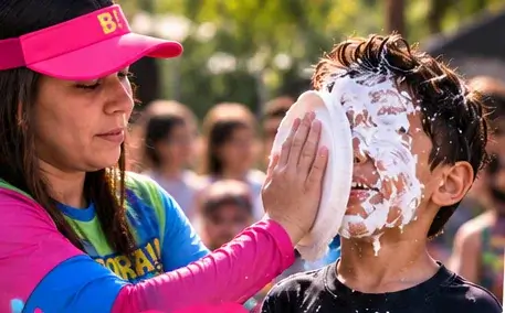Criança se divertindo com uma brincadeira de torta na cara